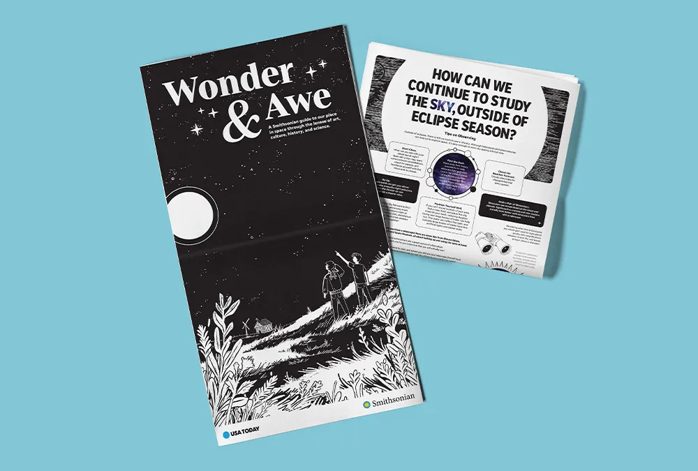 Light blue background with a newspaper extended featuring the words "Wonder & Awe" and a folded newspaper highlighting eclipse news