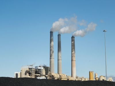 Piles of coal sit in front of a power plant in Utah. Such coal-fired power plants emit greenhouse gases that drive climate change.